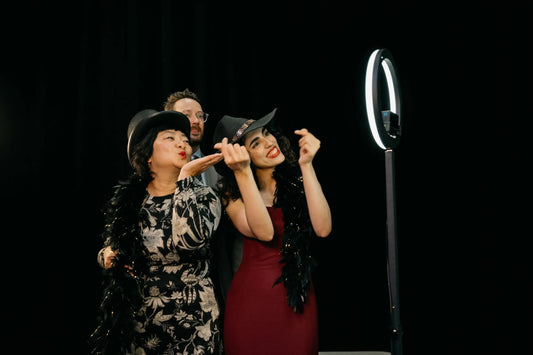 Guests having fun while posing with props in a 360 photo booth, smiling and interacting